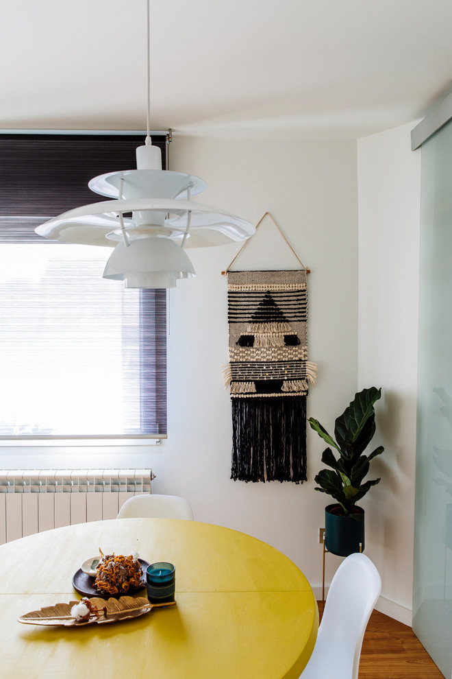 Modelo de comedor de cocina tropical pequeño con paredes blancas, suelo de madera en tonos medios y suelo marrón