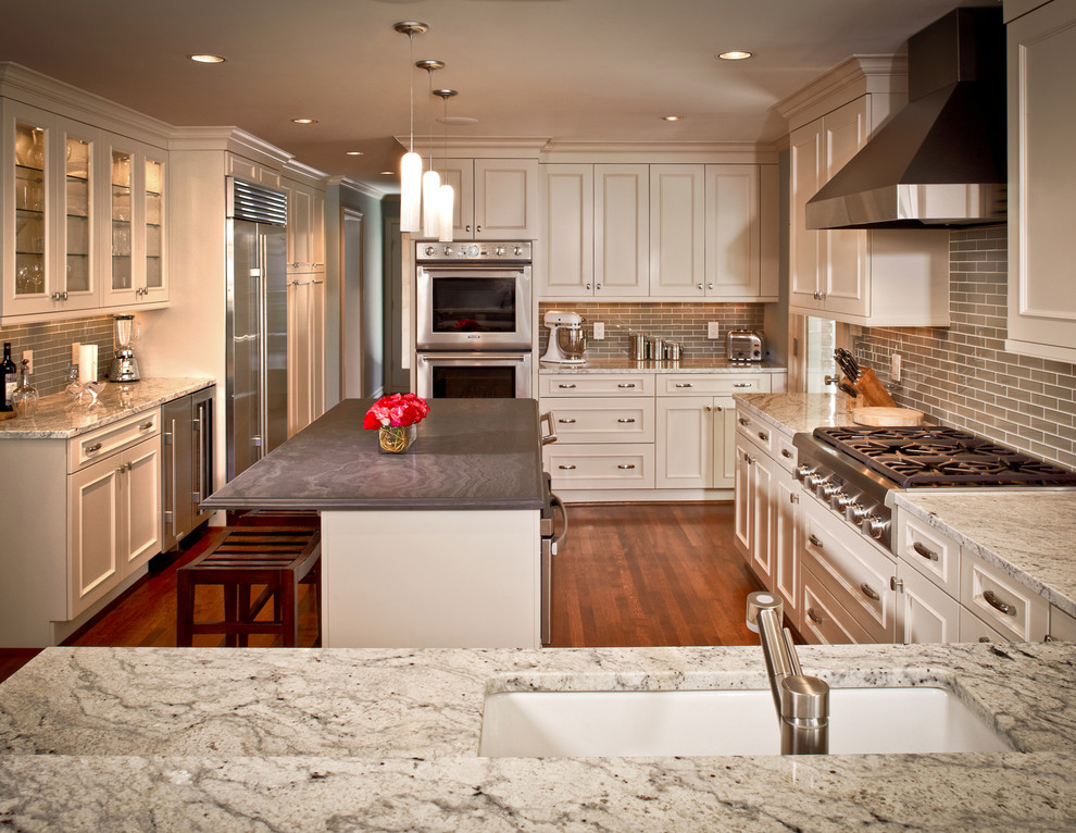 This is an example of a traditional u-shaped eat-in kitchen in Houston with white cabinets.