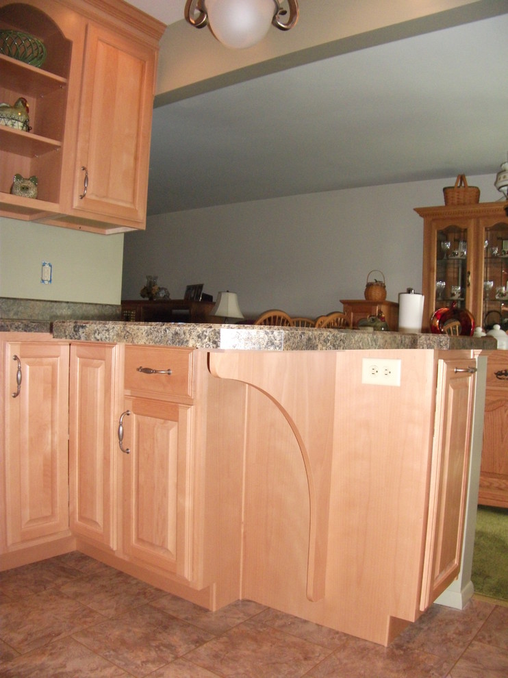 Example of a classic vinyl floor kitchen design with a drop-in sink, raised-panel cabinets, light wood cabinets, laminate countertops, green backsplash and white appliances