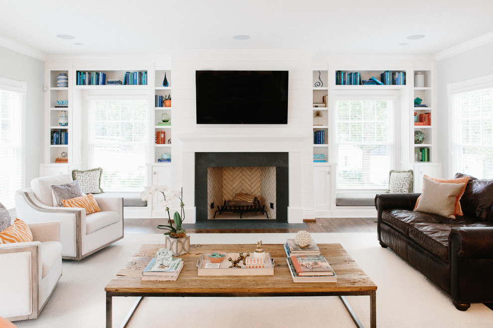 This is an example of a beach style living room in Louisville with a library, grey walls, dark hardwood floors, a standard fireplace and a wall-mounted tv.