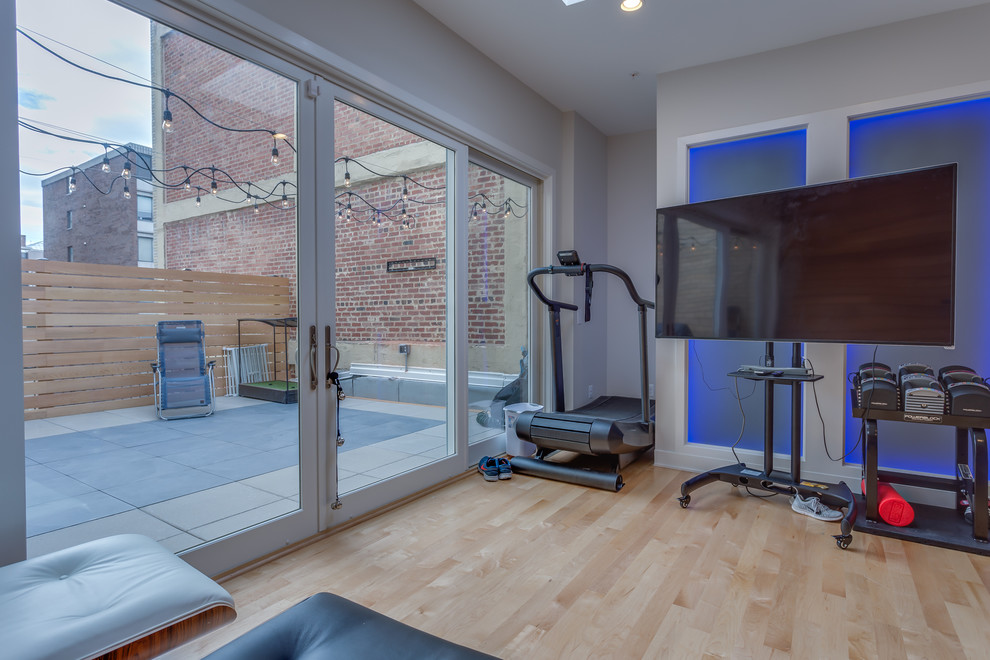Inspiration for a small modern home weight room in DC Metro with white walls, light hardwood floors and beige floor.