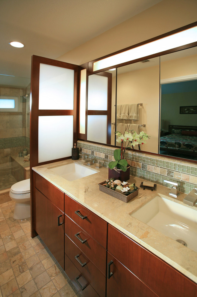 Design ideas for a mid-sized arts and crafts master bathroom in Los Angeles with an undermount sink, flat-panel cabinets, medium wood cabinets, marble benchtops, an alcove shower, a one-piece toilet, multi-coloured tile, glass tile, beige walls and marble floors.