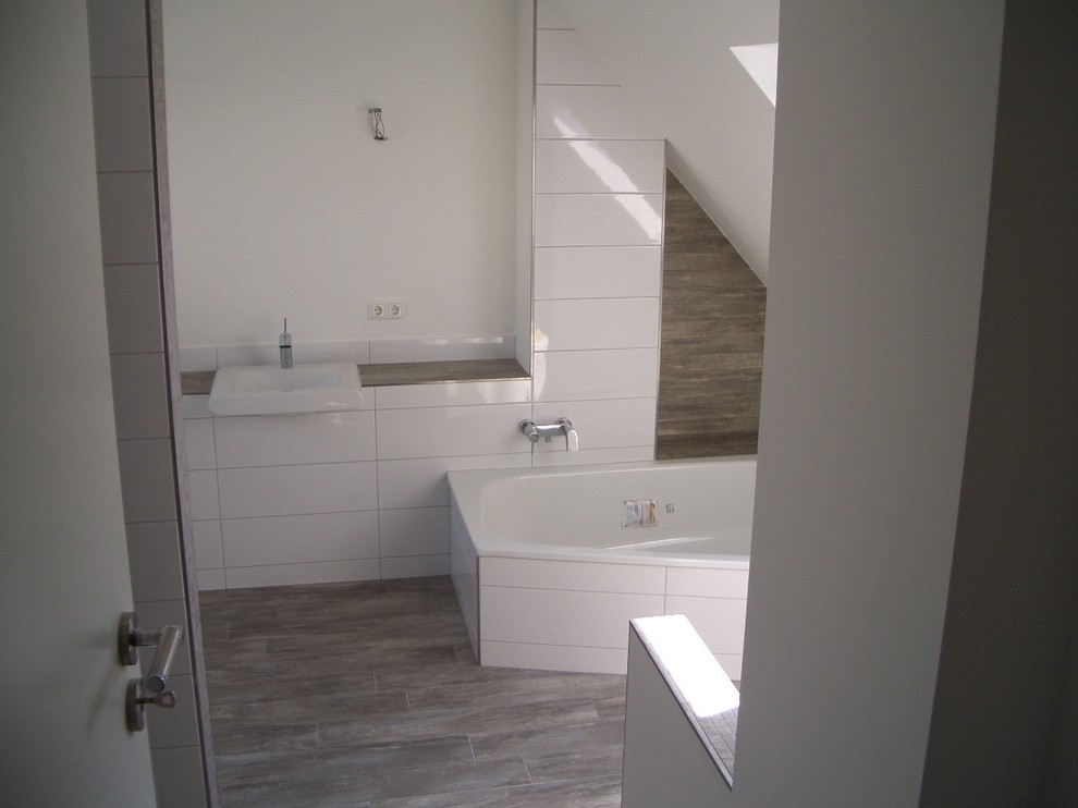 Design ideas for a mid-sized contemporary master bathroom in Hanover with a corner tub, a curbless shower, a wall-mount toilet, ceramic tile, white walls, ceramic floors, a drop-in sink, brown floor and an open shower.