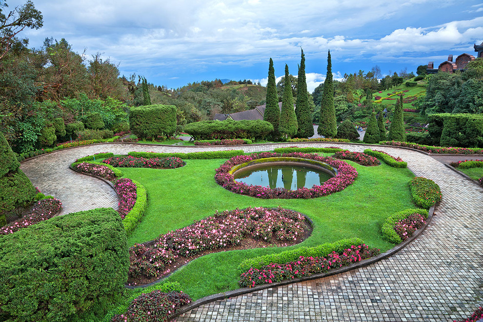Design ideas for an expansive traditional sloped full sun formal garden for spring in New York with a garden path and brick pavers.