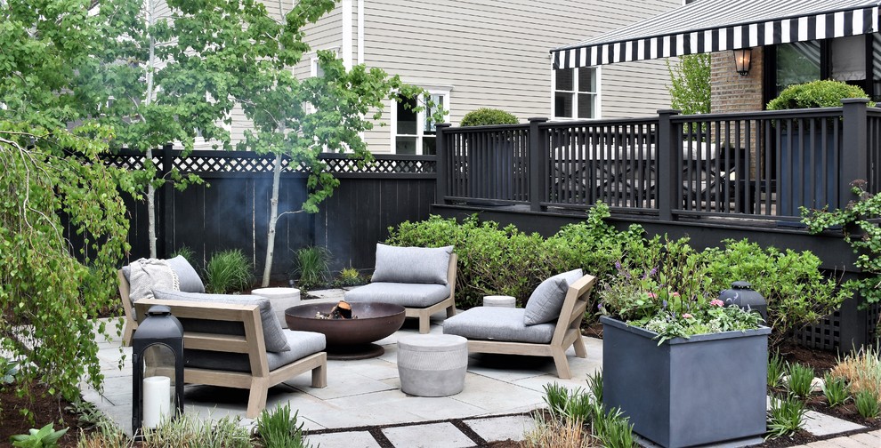 Small contemporary backyard patio in Chicago with a fire feature, natural stone pavers and a pergola.