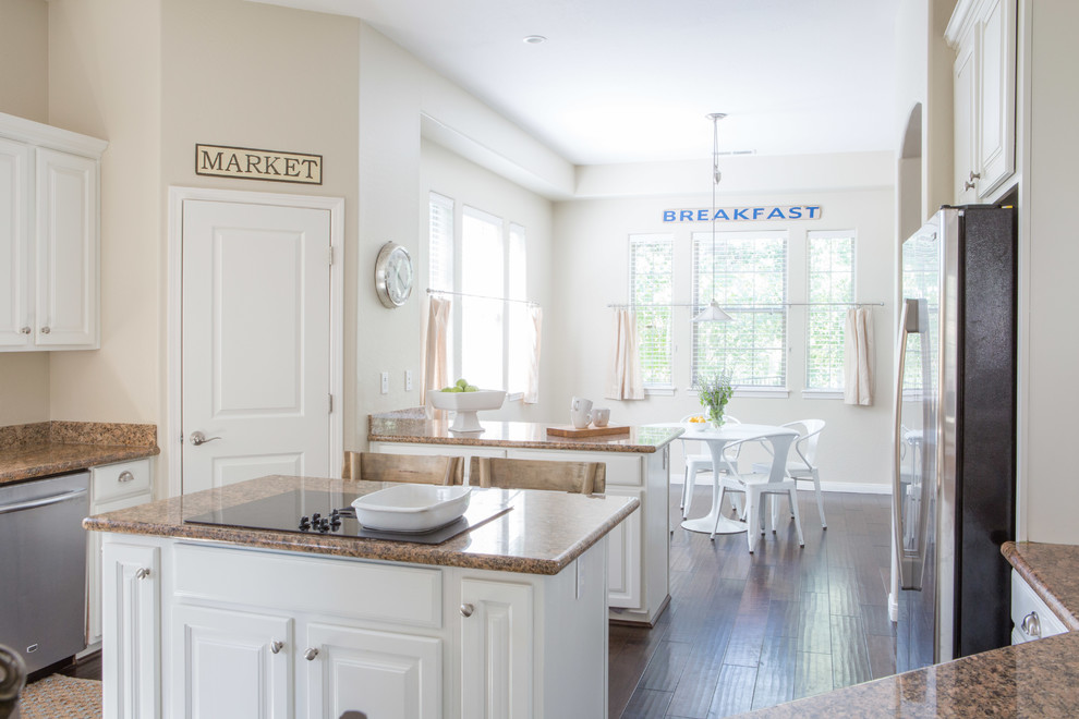Inspiration for a mid-sized transitional u-shaped dark wood floor and brown floor eat-in kitchen remodel in Phoenix with a drop-in sink, raised-panel cabinets, white cabinets, granite countertops, brown backsplash, stainless steel appliances and two islands