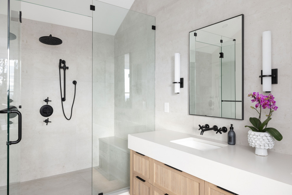 Cette image montre une douche en alcôve design en bois clair avec un placard à porte shaker, un carrelage gris, un lavabo encastré, une cabine de douche à porte battante, un plan de toilette blanc, meuble double vasque et meuble-lavabo encastré.