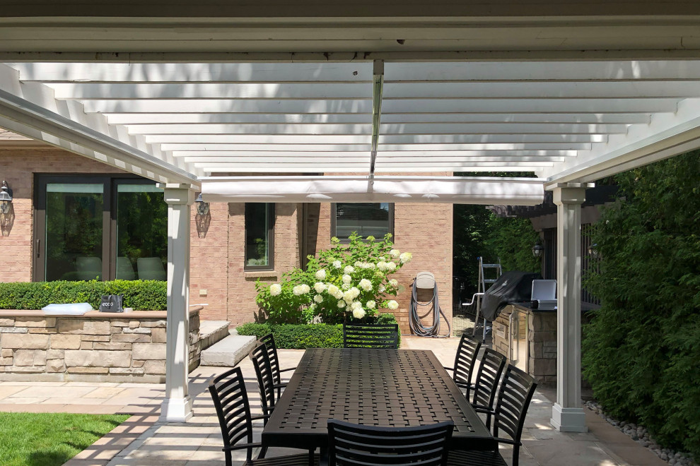 Inspiration for a large traditional backyard patio in Toronto with concrete pavers and a pergola.