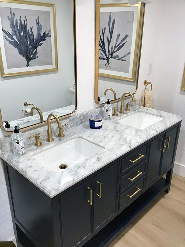 Mid-sized beach style master white tile and porcelain tile laminate floor, brown floor and double-sink bathroom photo in Orlando with raised-panel cabinets, blue cabinets, a two-piece toilet, white walls, an undermount sink, quartz countertops, gray countertops and a freestanding vanity