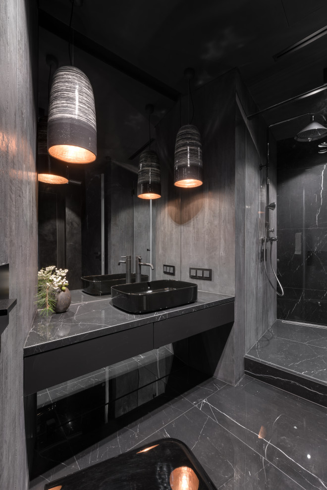 На фото: ванная комната среднего размера: освещение в стиле лофт с плоскими фасадами, черными фасадами, открытым душем, серой плиткой, плиткой из листового камня, серыми стенами, мраморным полом, душевой кабиной, настольной раковиной, мраморной столешницей, черным полом, открытым душем, черной столешницей, тумбой под одну раковину, подвесной тумбой, многоуровневым потолком и панелями на стенах с