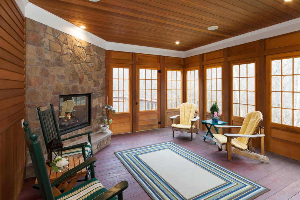 Design ideas for a mid-sized traditional sunroom in Boston with dark hardwood floors, a corner fireplace, a stone fireplace surround, a standard ceiling and brown floor.