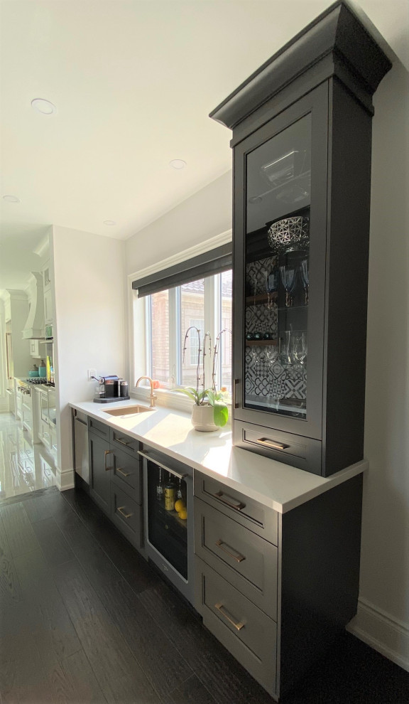 Inspiration for a large transitional l-shaped porcelain tile and white floor open concept kitchen remodel in Toronto with an undermount sink, recessed-panel cabinets, white cabinets, quartz countertops, white backsplash, stone slab backsplash, stainless steel appliances, an island and white countertops