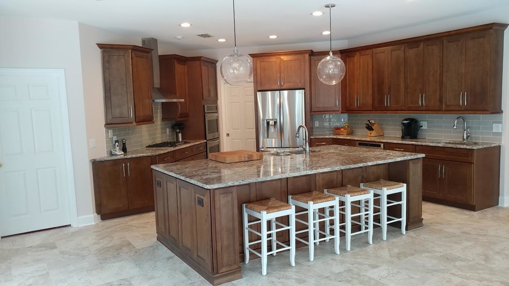 Large transitional u-shaped porcelain tile and beige floor kitchen photo in Miami with shaker cabinets, medium tone wood cabinets, granite countertops, gray backsplash, stainless steel appliances, an island, an undermount sink, subway tile backsplash and gray countertops