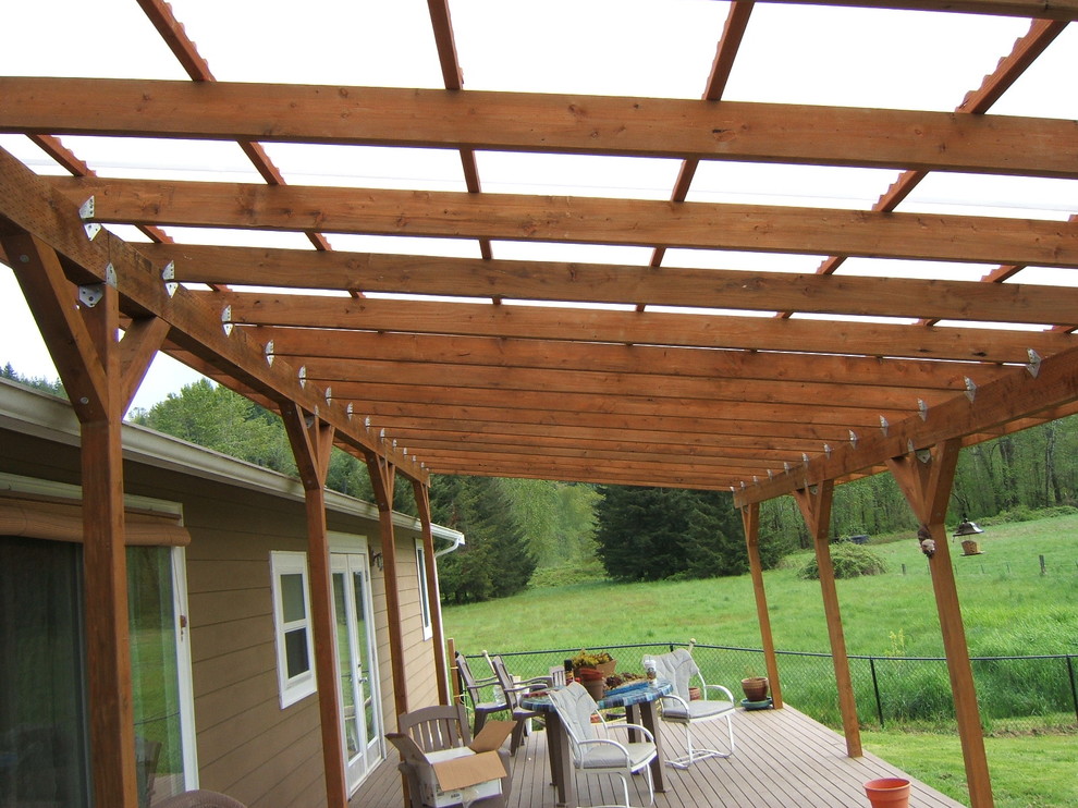 This is an example of a mid-sized traditional backyard deck in Seattle with a pergola.