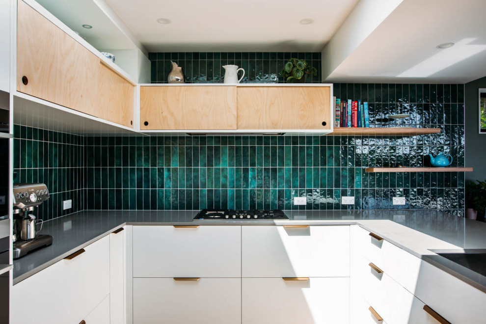 Idéer för att renovera ett mellanstort eklektiskt grå grått kök, med en undermonterad diskho, granitbänkskiva, grönt stänkskydd, stänkskydd i keramik, svarta vitvaror och en halv köksö