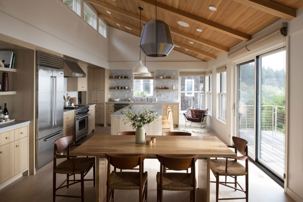 Esempio di una sala da pranzo aperta verso la cucina costiera con pareti bianche, parquet chiaro e soffitto in legno