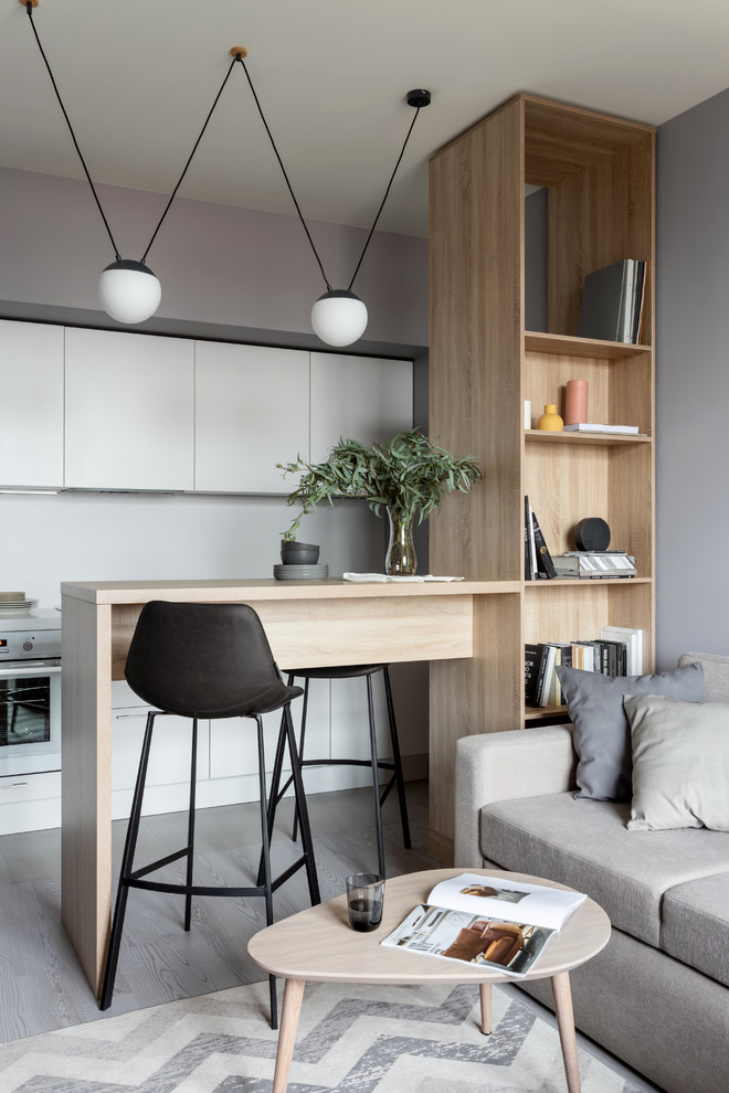 Mid-sized scandinavian open plan kitchen in Moscow with flat-panel cabinets, white cabinets, white splashback, white appliances, light hardwood floors and a peninsula.