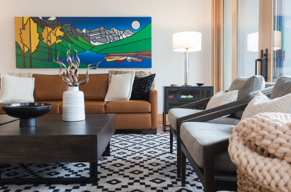 Mittelgroßes Uriges Wohnzimmer mit weißer Wandfarbe, braunem Holzboden und buntem Boden in Calgary