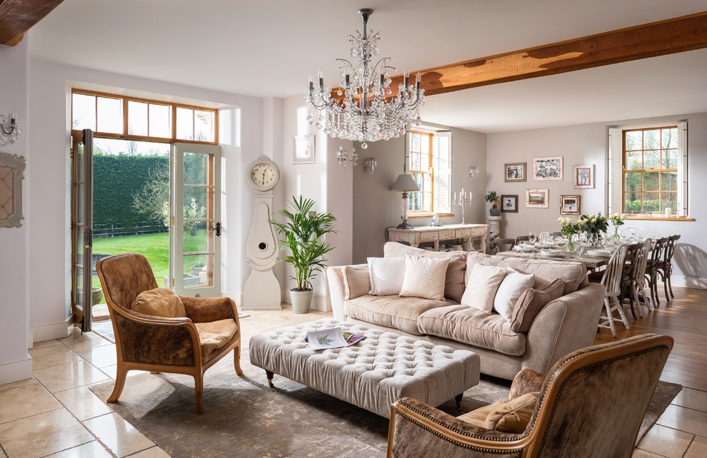 This is an example of a large country open concept living room in Cornwall with white walls and beige floor.