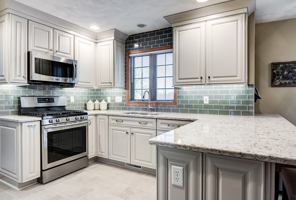 Eat-in kitchen - mid-sized transitional l-shaped porcelain tile eat-in kitchen idea in Chicago with an undermount sink, raised-panel cabinets, white cabinets, quartzite countertops, gray backsplash, subway tile backsplash and stainless steel appliances