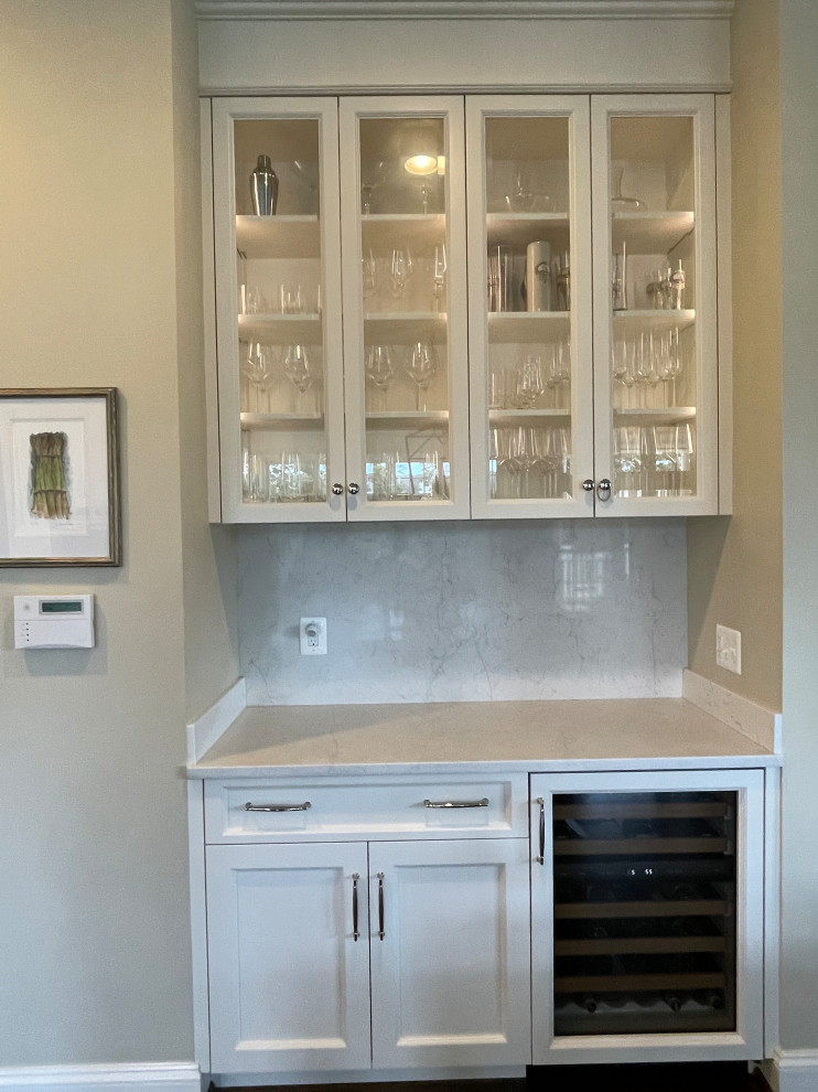 Inspiration for a mid-sized u-shaped medium tone wood floor and brown floor eat-in kitchen remodel in DC Metro with a farmhouse sink, shaker cabinets, white cabinets, quartz countertops, white backsplash, quartz backsplash, stainless steel appliances, an island and white countertops