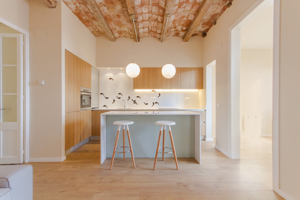Inspiration for a large scandinavian u-shaped kitchen in Barcelona with flat-panel cabinets, medium wood cabinets, solid surface benchtops, white splashback, stainless steel appliances, light hardwood floors and with island.