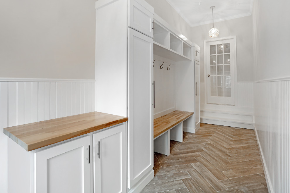 Ispirazione per una cabina armadio unisex classica di medie dimensioni con ante in stile shaker, ante bianche, pavimento in legno massello medio e pavimento multicolore