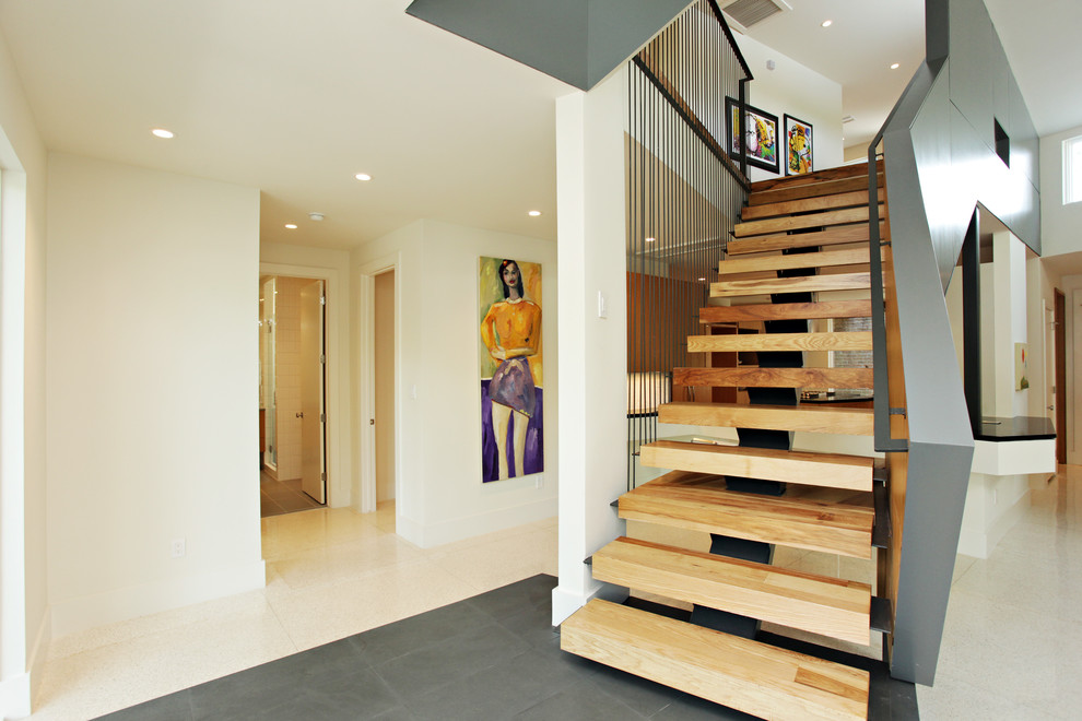 Inspiration for a large contemporary wood straight staircase in Austin with open risers and metal railing.