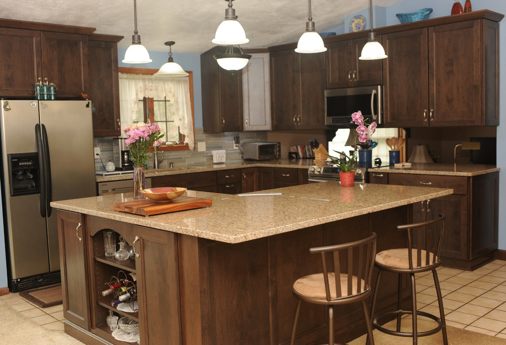 Mid-sized transitional l-shaped ceramic tile eat-in kitchen photo with an undermount sink, recessed-panel cabinets, dark wood cabinets, granite countertops, multicolored backsplash, glass tile backsplash, stainless steel appliances and an island