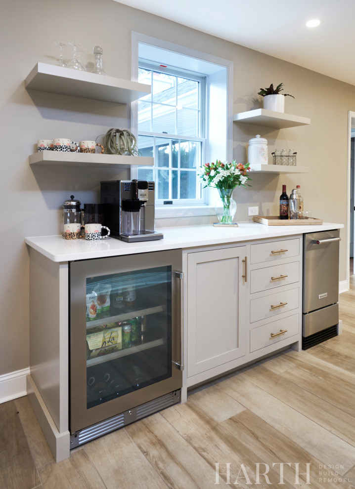 Photo of a small traditional single-wall dry bar in Philadelphia with shaker cabinets, beige cabinets, engineered stone countertops, porcelain flooring, brown floors and white worktops.