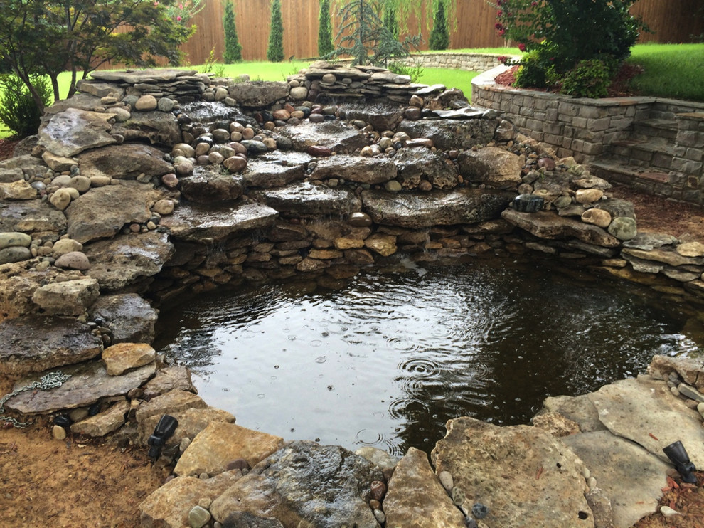Photo of a mid-sized rustic shade backyard stone formal garden.