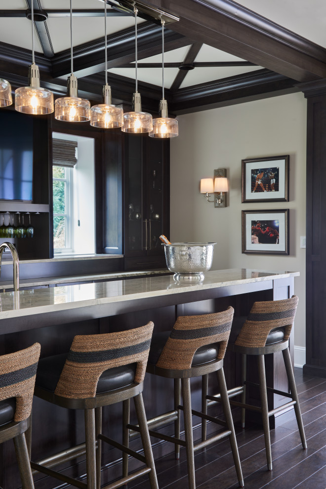 Inspiration for a transitional galley seated home bar in Philadelphia with glass-front cabinets, black cabinets, black splashback, dark hardwood floors and brown floor.