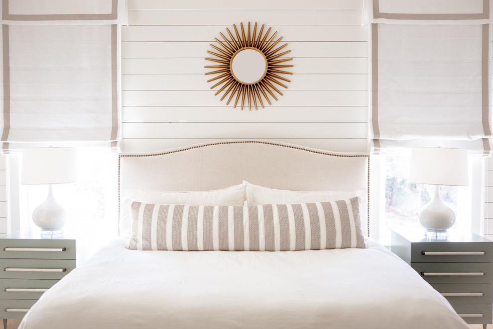 This is an example of a beach style master bedroom in Other with white walls.