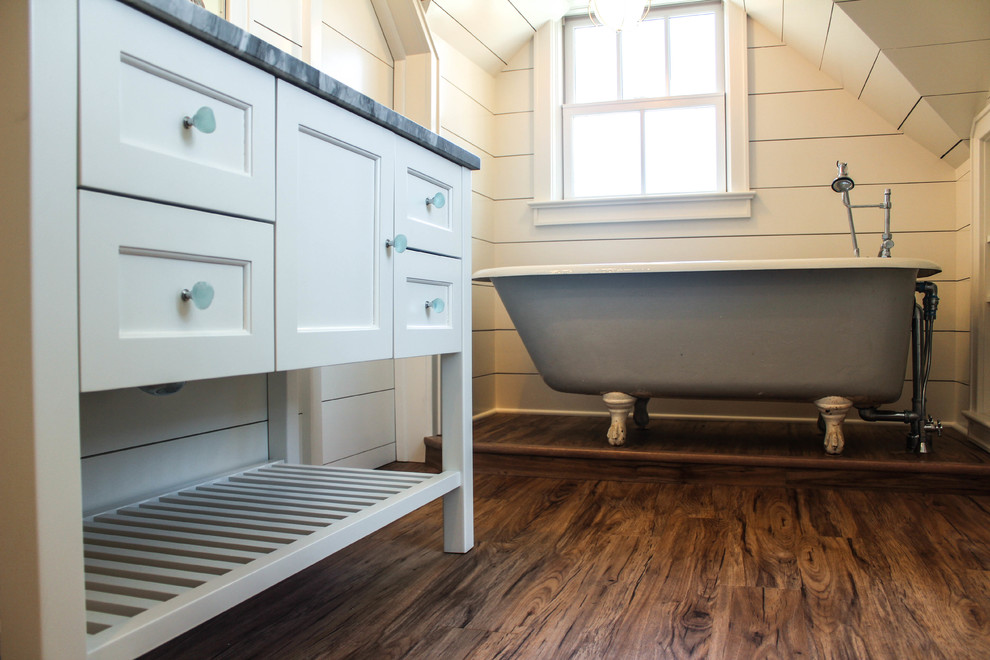 This is an example of a small country master bathroom in New York with an alcove shower, gray tile, white walls, an integrated sink, furniture-like cabinets, white cabinets, a claw-foot tub, a one-piece toilet and dark hardwood floors.