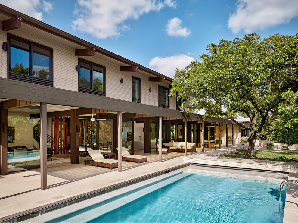 Inspiration for a large contemporary backyard rectangular lap pool in Austin with decking and a pool house.