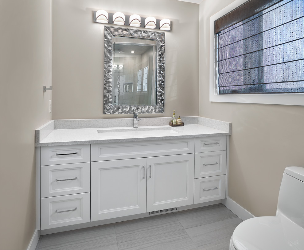 Inspiration for a small transitional master ceramic tile and gray floor bathroom remodel in Edmonton with recessed-panel cabinets, white cabinets, a one-piece toilet, beige walls, an undermount sink and quartz countertops