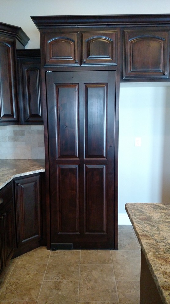 Inspiration for a large transitional u-shaped porcelain tile open concept kitchen remodel with an undermount sink, raised-panel cabinets, dark wood cabinets, granite countertops, beige backsplash, stone tile backsplash, stainless steel appliances and an island
