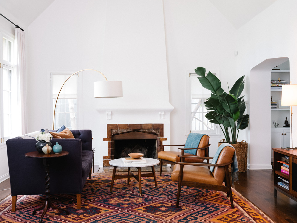 This is an example of a mid-sized transitional formal enclosed living room in Los Angeles with white walls, dark hardwood floors, a standard fireplace and brown floor.