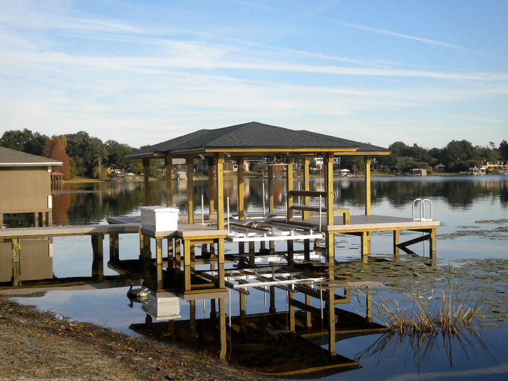 This is an example of a mid-sized beach style backyard deck in Orlando with with dock.