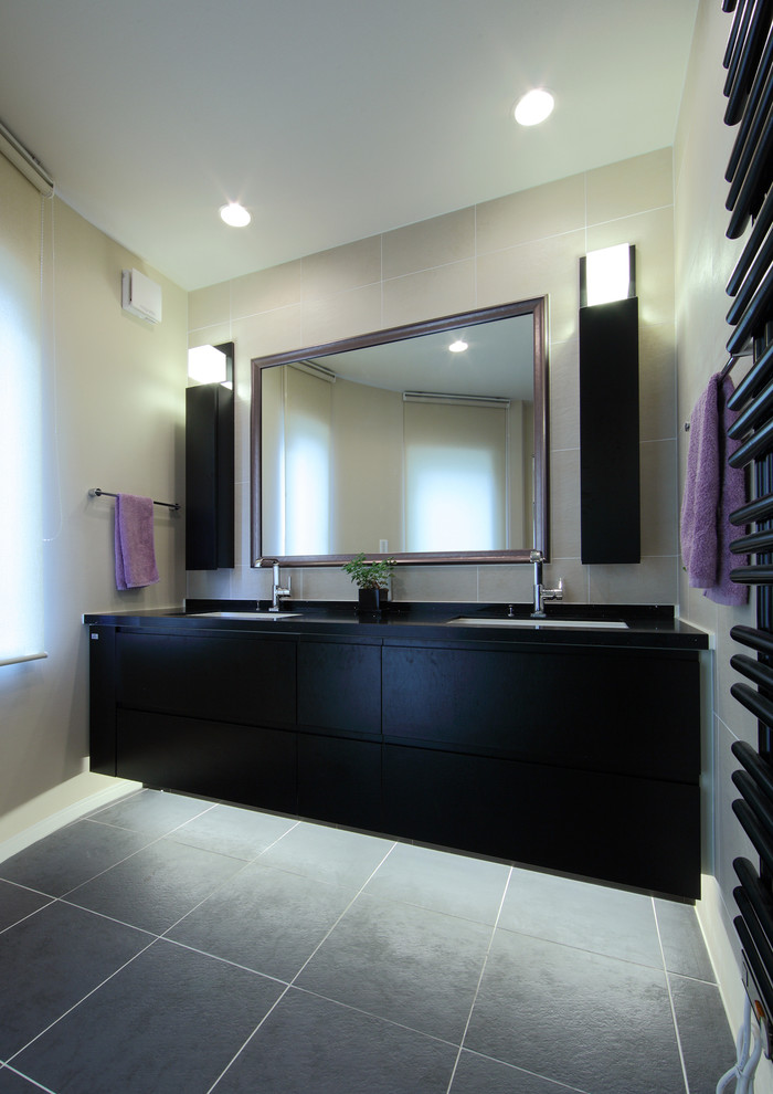 Inspiration for a contemporary powder room in Yokohama with flat-panel cabinets, black cabinets, beige walls and grey floor.