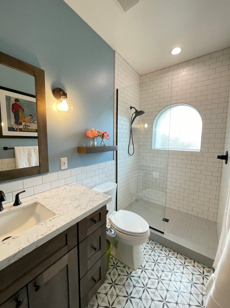 Design ideas for a mid-sized transitional kids bathroom in Phoenix with recessed-panel cabinets, dark wood cabinets, an alcove shower, yellow tile, travertine, blue walls, porcelain floors, an undermount sink, engineered quartz benchtops, grey floor, an open shower, white benchtops, a single vanity and a built-in vanity.