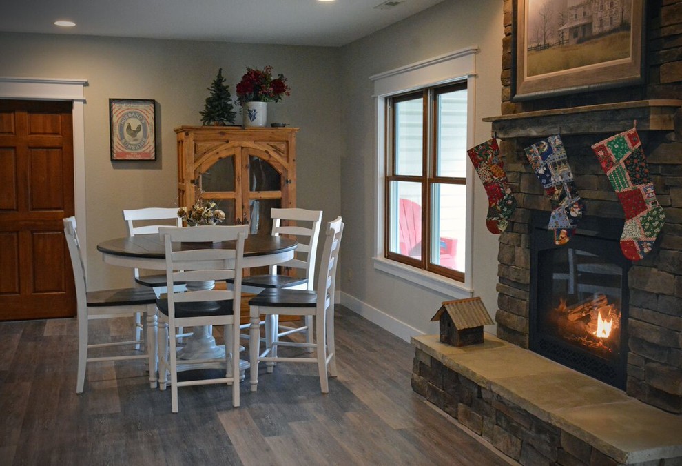 Inspiration for a large transitional walk-out medium tone wood floor and brown floor basement remodel with beige walls, a standard fireplace and a stone fireplace