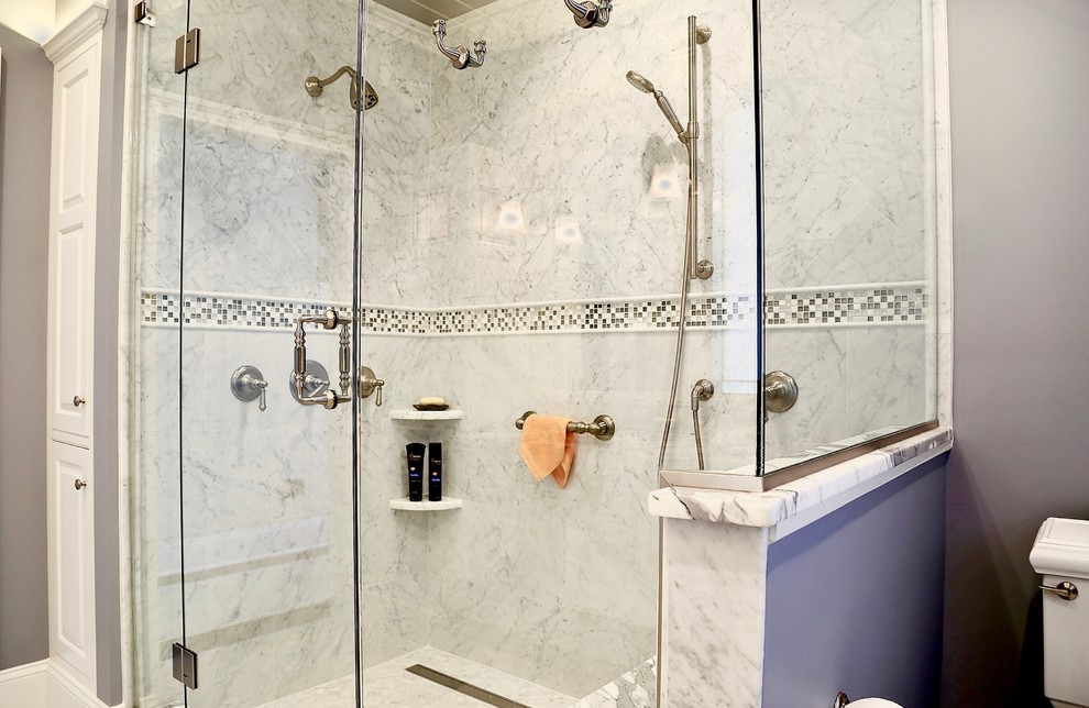This is an example of a mid-sized transitional master bathroom in Bridgeport with raised-panel cabinets, white cabinets, a corner shower, a one-piece toilet, white tile, marble, grey walls, marble floors, an undermount sink, marble benchtops and white floor.