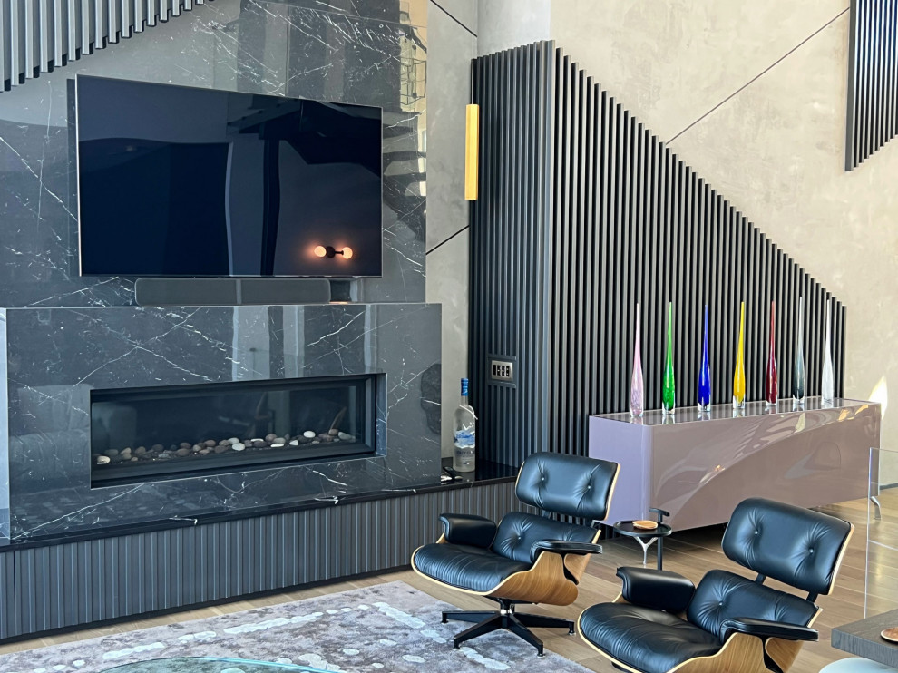 Стильный дизайн: большая открытая гостиная комната в стиле фьюжн с черными стенами, паркетным полом среднего тона, горизонтальным камином, фасадом камина из камня, телевизором на стене и коричневым полом - последний тренд
