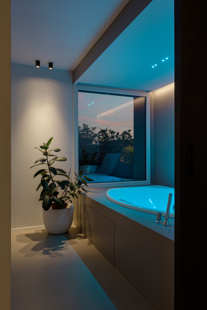 Пример оригинального дизайна: маленькая ванная комната в современном стиле с гидромассажной ванной, душем над ванной, зеленой плиткой, стеклянной плиткой, серыми стенами, бетонным полом, серым полом, душем с распашными дверями, серой столешницей, нишей, встроенной тумбой и многоуровневым потолком для на участке и в саду