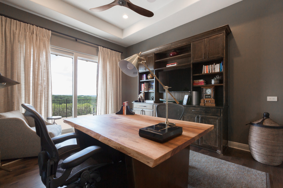 This is an example of a mid-sized transitional study room in Austin with grey walls, dark hardwood floors, no fireplace, a freestanding desk and brown floor.