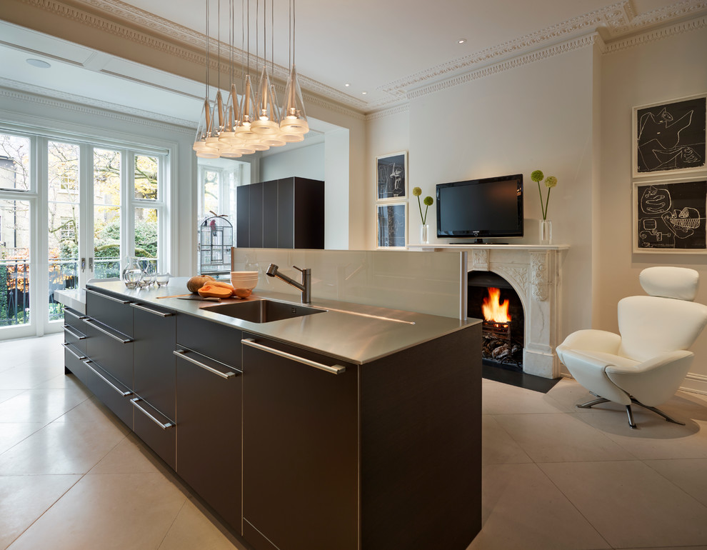 This is an example of a contemporary kitchen in London with an undermount sink, flat-panel cabinets, dark wood cabinets, stainless steel benchtops and with island.