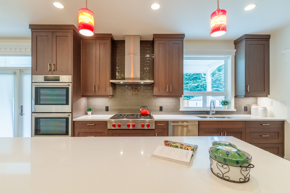 Design ideas for a modern l-shaped eat-in kitchen in Vancouver with a double-bowl sink, shaker cabinets, medium wood cabinets, quartzite benchtops, beige splashback, glass tile splashback, stainless steel appliances, light hardwood floors and with island.