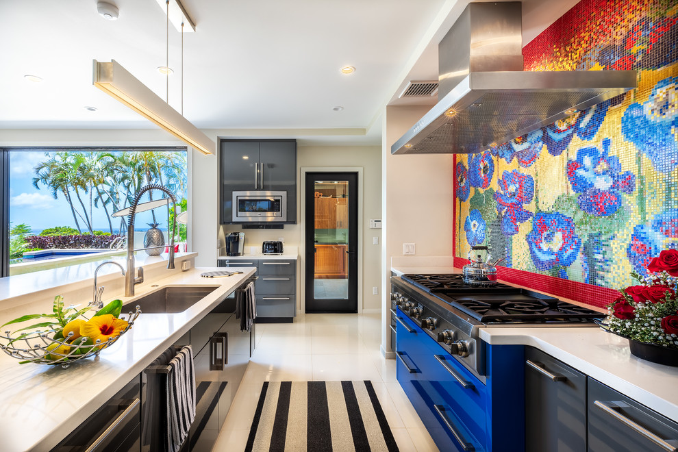 Inspiration for a large modern u-shaped eat-in kitchen in Hawaii with an undermount sink, flat-panel cabinets, grey cabinets, solid surface benchtops, multi-coloured splashback, mosaic tile splashback, panelled appliances, with island, white floor and white benchtop.