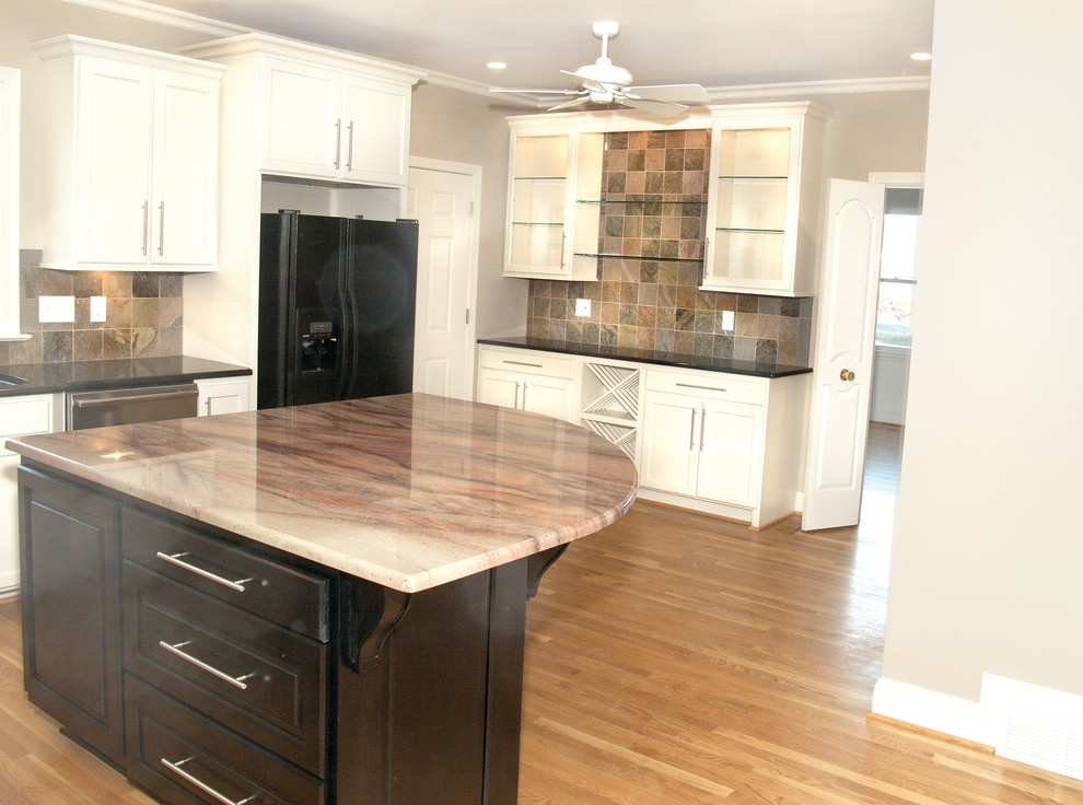 Kitchen - large transitional medium tone wood floor kitchen idea with an undermount sink, recessed-panel cabinets, white cabinets, granite countertops, multicolored backsplash, stone tile backsplash, stainless steel appliances and an island